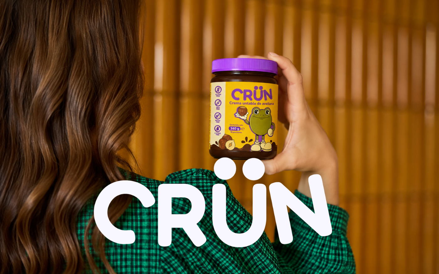 Mujer sosteniendo un frasco de crema de avellana Crün con el logotipo de la marca en grande
