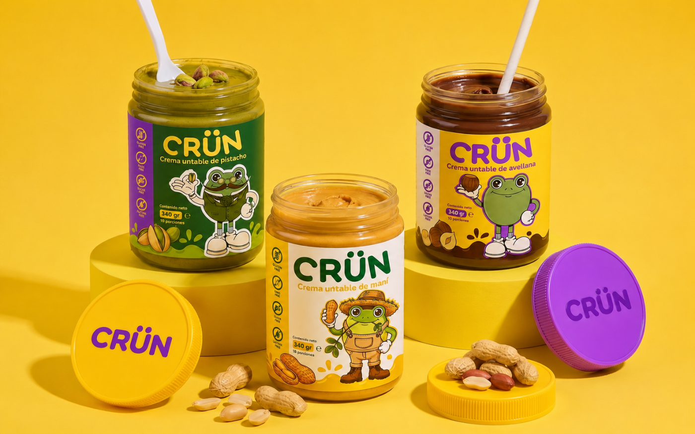 Los tres sabores de Crün, pistacho, maní y avellana, con sus etiquetas y tapas de color sobre fondo amarillo